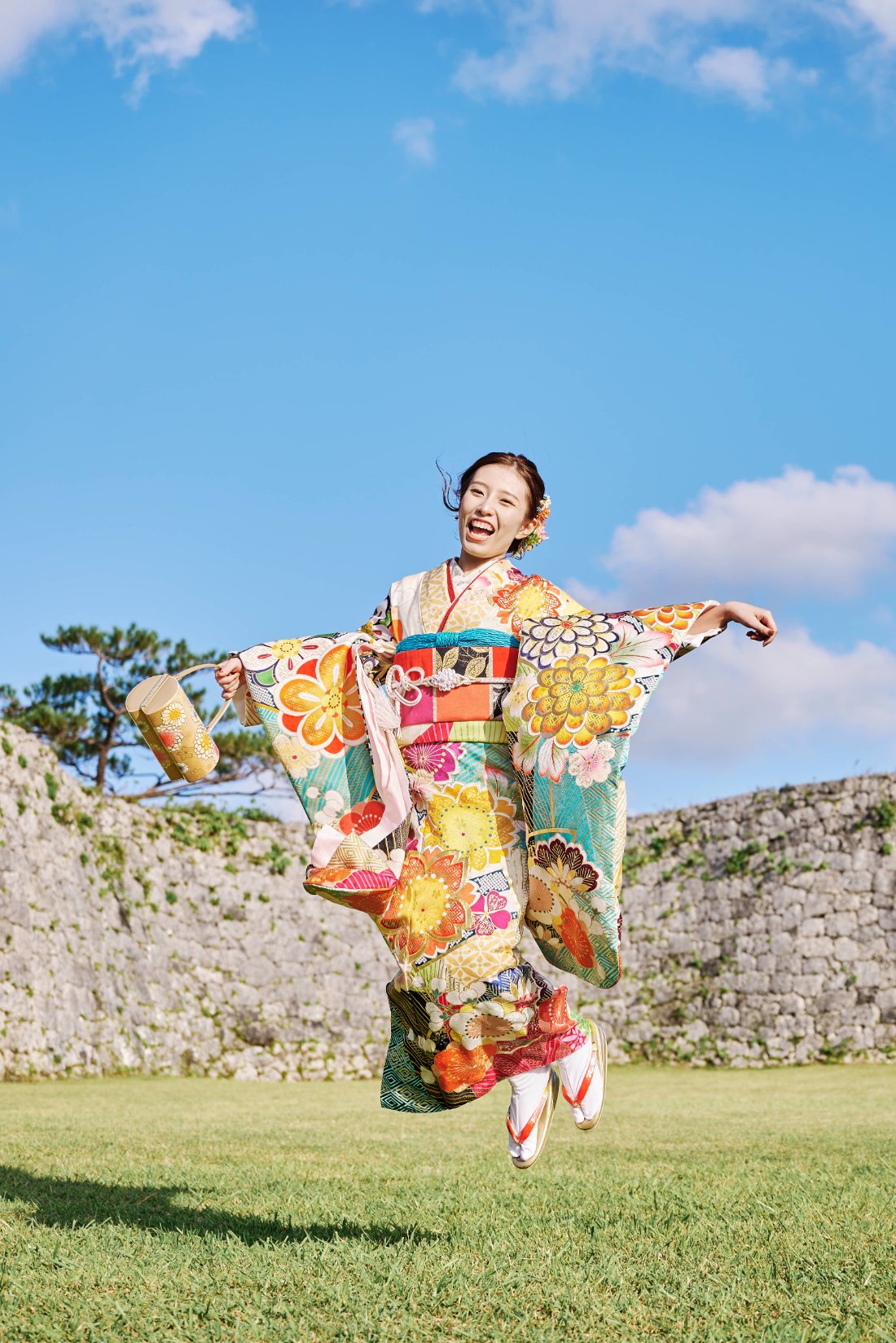 沖縄の石垣を背景にした晴れ着の記念撮影